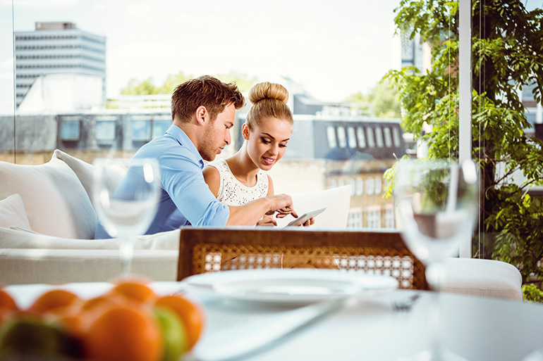 Couple using a digital tablet to search new condos in downtown Toronto