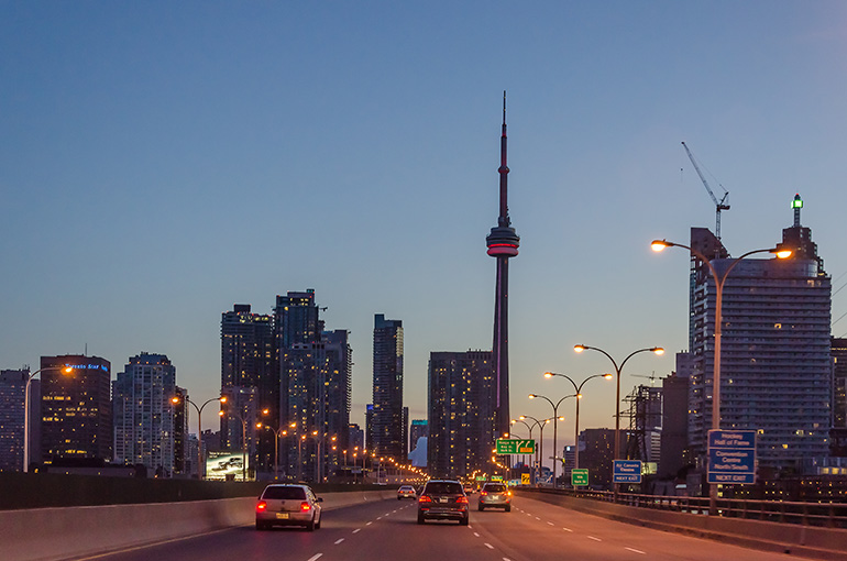 Toronto skyling including new condo projects as seen from highway at night with cars